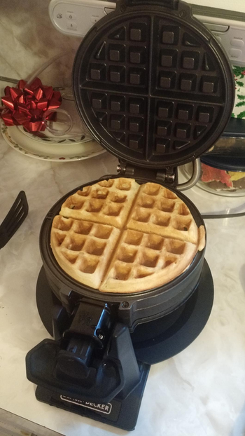 Reviewer image of black waffle maker with waffle inside