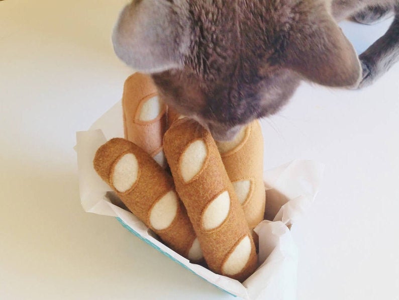 four small cat toys made to look like a French baguette