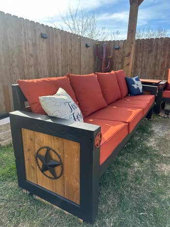 Outdoor woody  sofa with prima  accents and reddish  cushions, acceptable   successful  a backyard