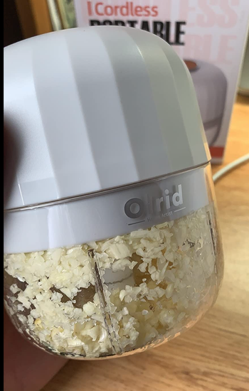 small white cylinder machine full of chopped garlic 