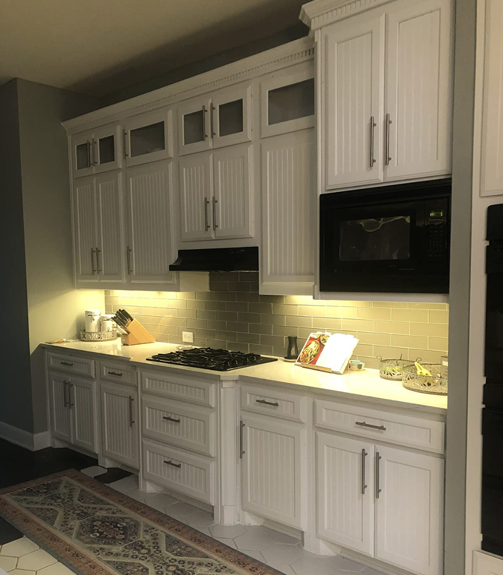 A kitchen with lights installed under the cabinets illuminating the counters 