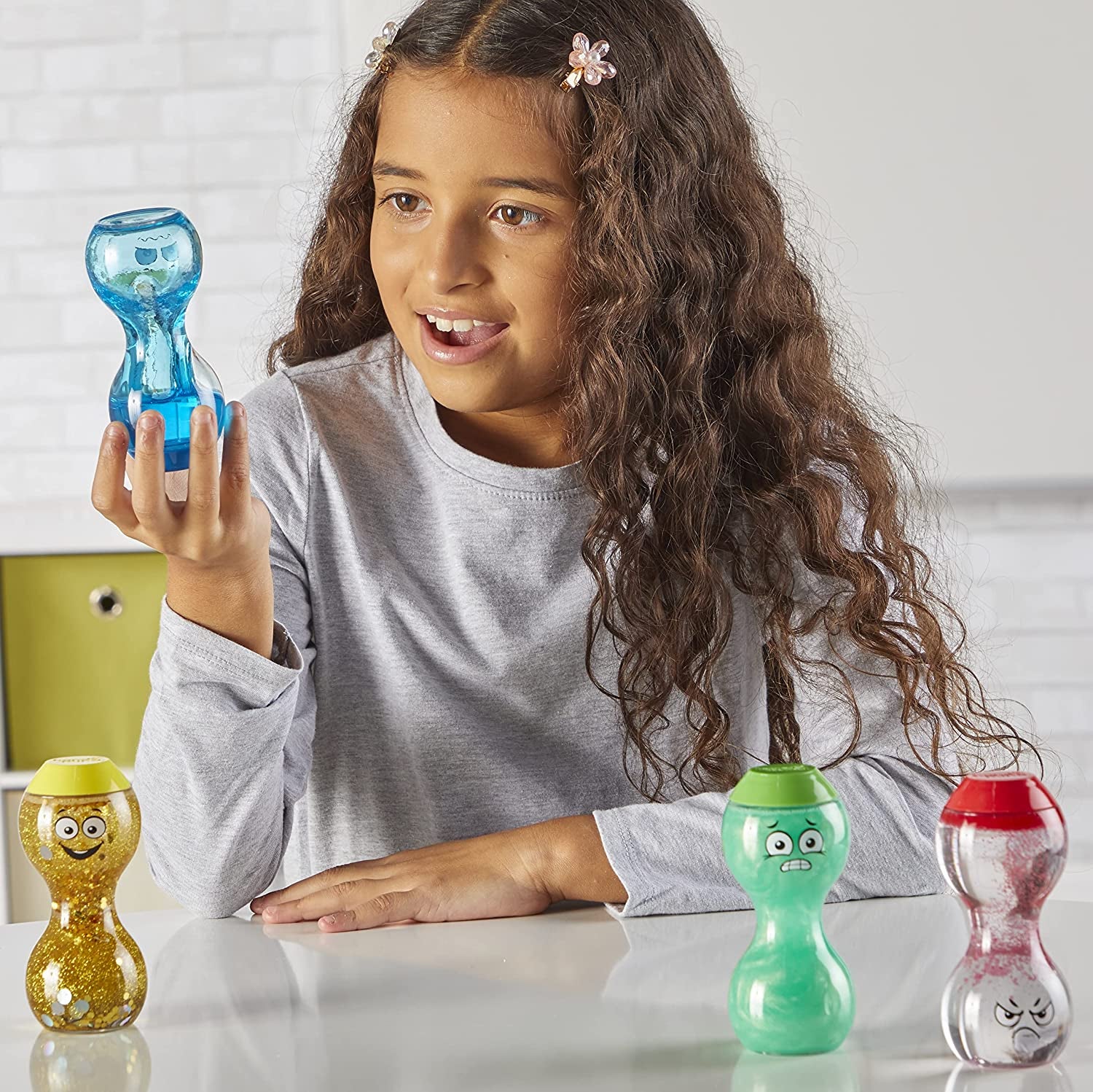 a child holding one of the sensory bottles