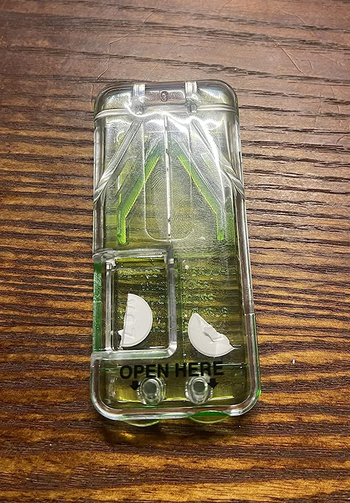 a reviewer photo of the pill cutter closed with a split pill inside 