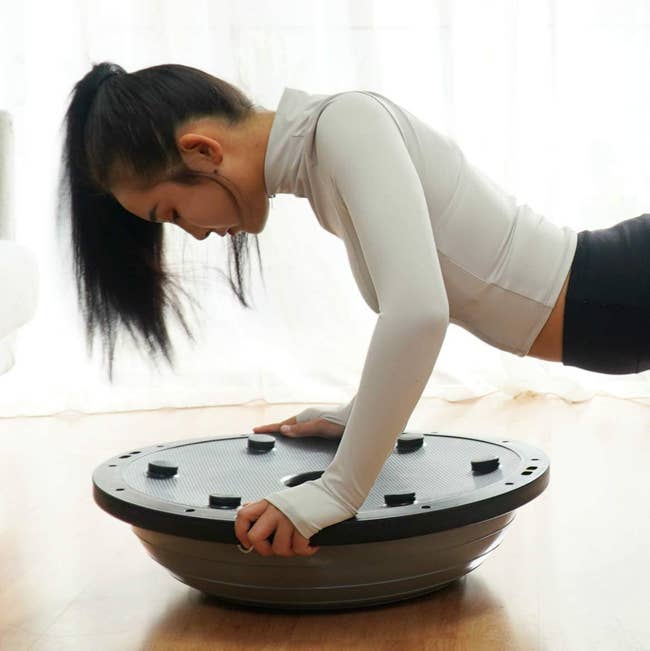 model in plank position on balance ball trainer