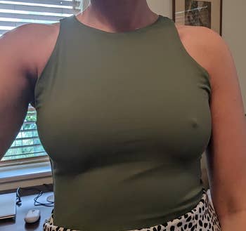 a reviewer wearing the nipple cover on one breast and not the other under a tight tank top 