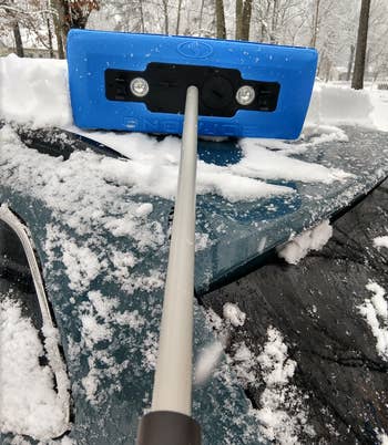 reviewer's blue Snow Joe broom on their car
