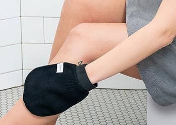 model wearing the glove and using it on their leg in the shower
