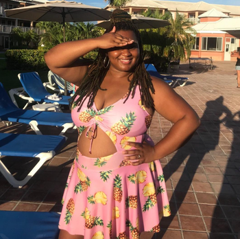 Reviewer in a pink swimdress with pineapples and lemons with a cutout in the middle 
