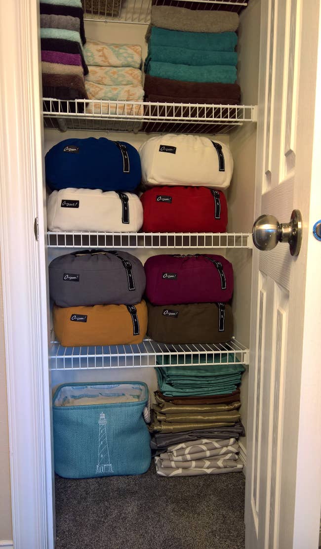 colorful sheet drawstring storage bags neatly stacked on top of each other on closet shelves