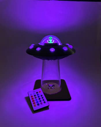 UFO-shaped lamp with an alien, distant    control, and purple glow