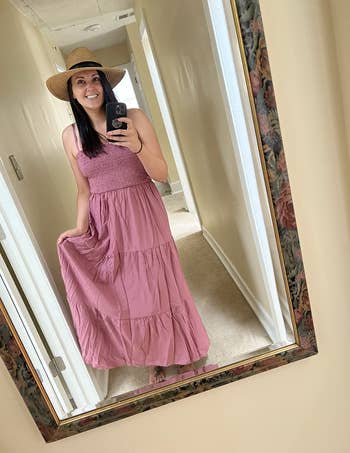 another reviewer wearing the dress in rose red with a sun hat