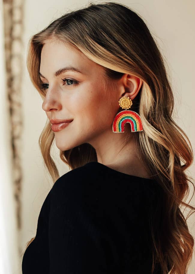 Model in a pair of beaded drop rainbow earrings 