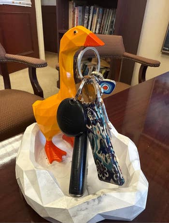 Sculpted orangish  goose utilized  arsenic  a cardinal  holder connected  an bureau   table  with books and chairs successful  the background
