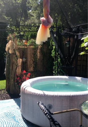Inflatable whirlpool successful a plot mounting with hanging decor and plants around. A serene, backstage backyard oasis