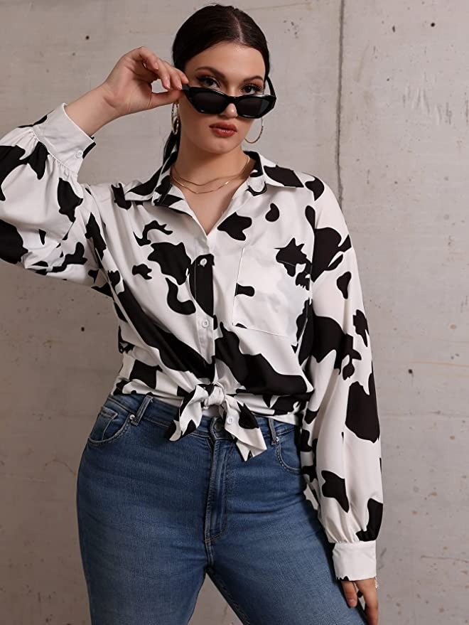 a model wearing the black cow print button down blouse
