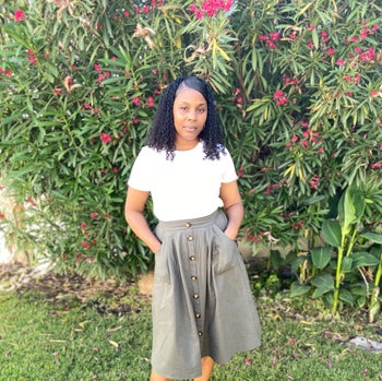 Reviewer is wearing a grey button front skirt and a white top