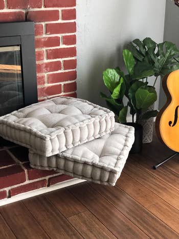 reviewer's two gray pillows next to fireplace 