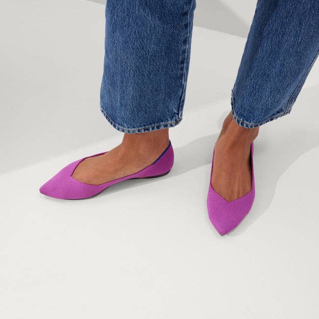 model wearing pink pointed-toe flats