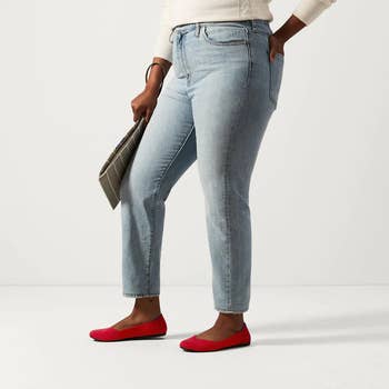 model wearing the flats in bright red paired with jeans