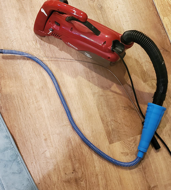 A blue hose attachment on a regular vacuum 