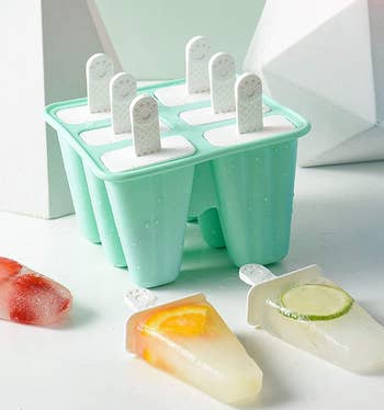 the light green popsicle mold next to a few fruit popsicles