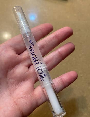 reviewer holding the teeth whitening pen