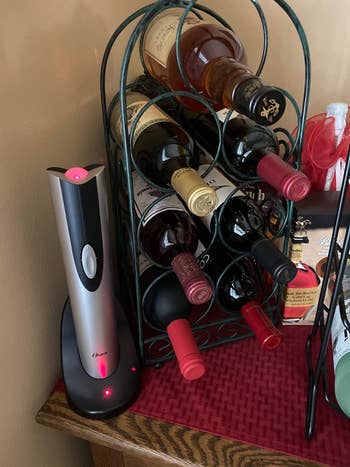 A reviewer's wine opener next to a wine rack 