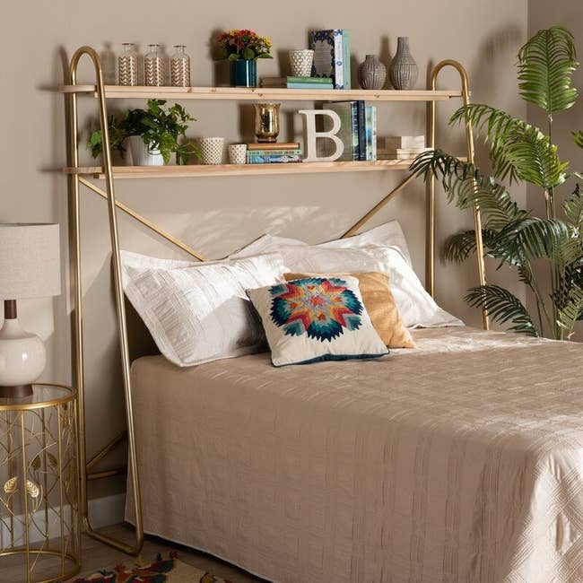 the gold metal shelf sitting above a bed