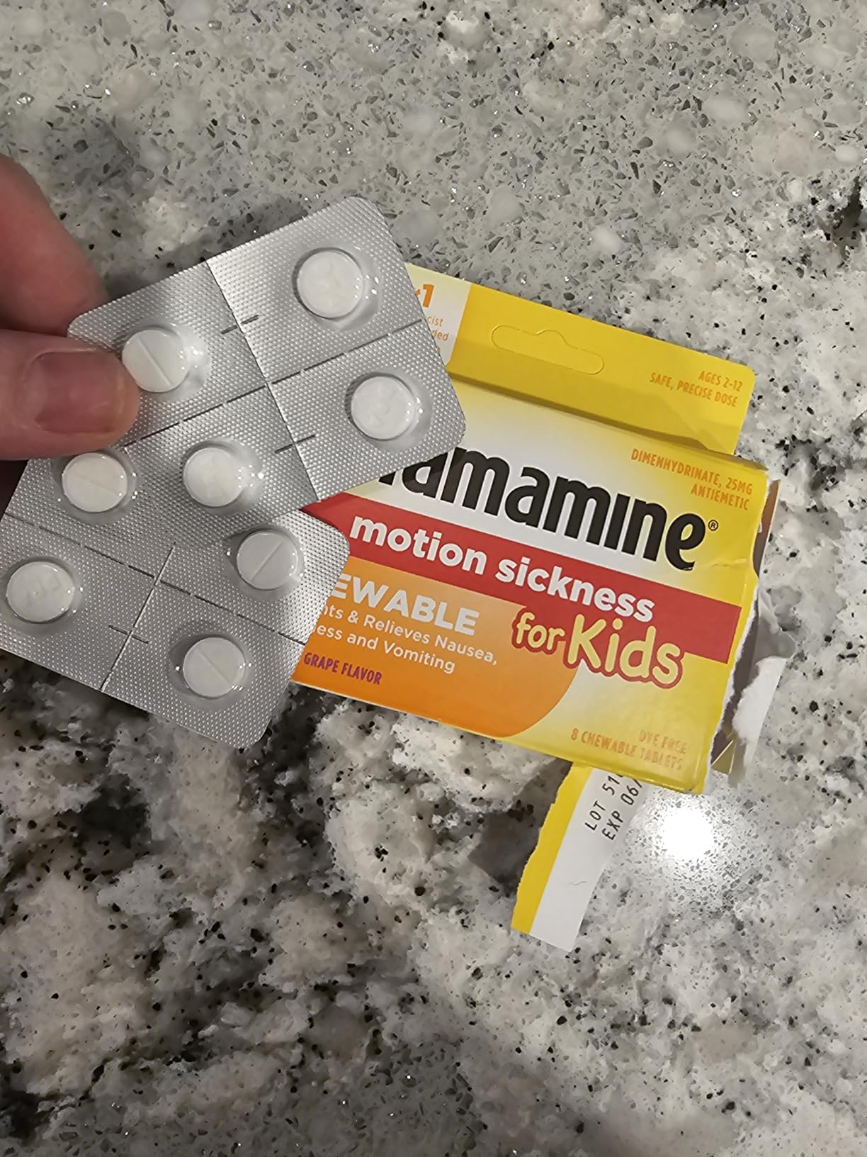 Chewable Dramamine for kids, grape flavor, shown with blister battalion  connected  a marble surface
