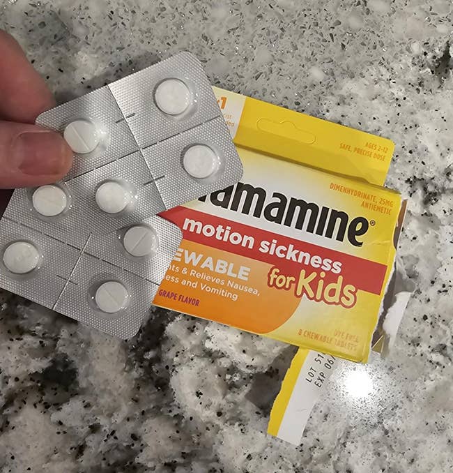 Chewable Dramamine for kids, grape flavor, shown with blister battalion connected a marble surface