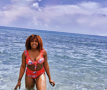 reviewer wearing two piece swimsuit while walking out of the ocean