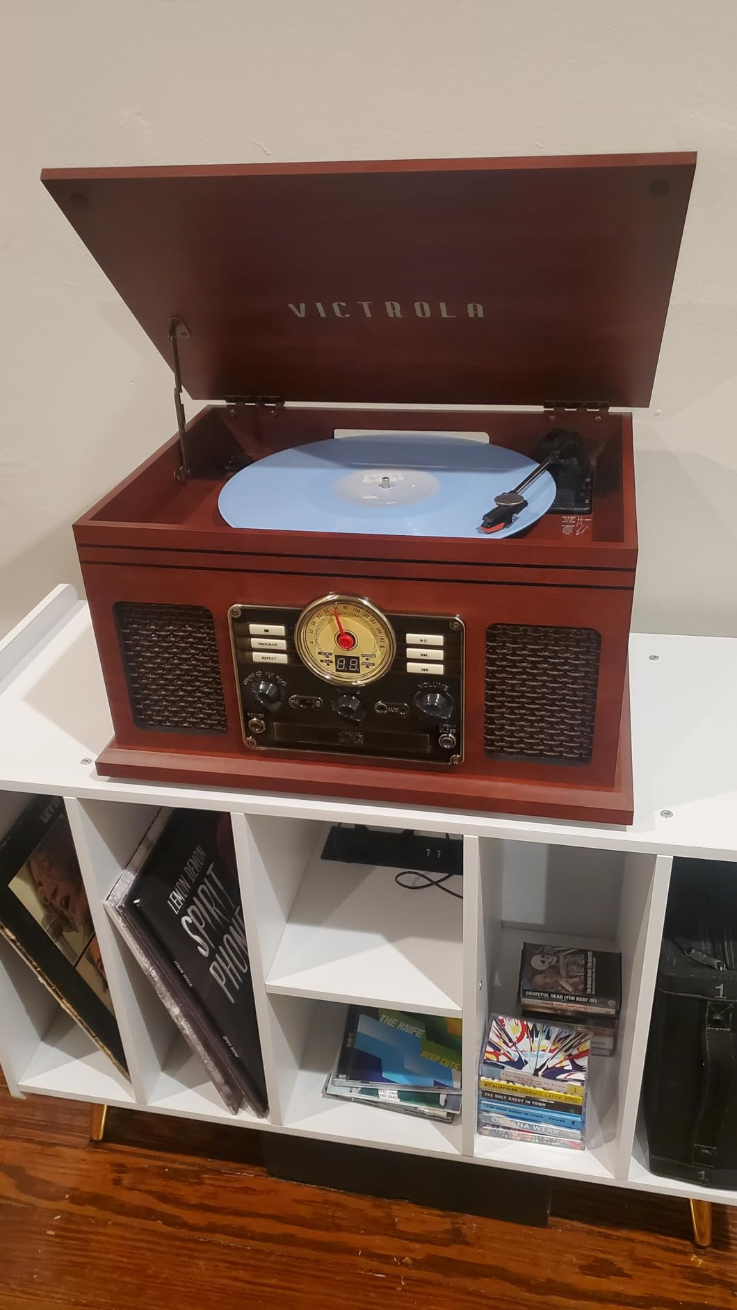 Open retro-style grounds   subordinate    with a vinyl connected  a shelf, surrounded by books and CDs. Suitable for adding a vintage flair to location  decor