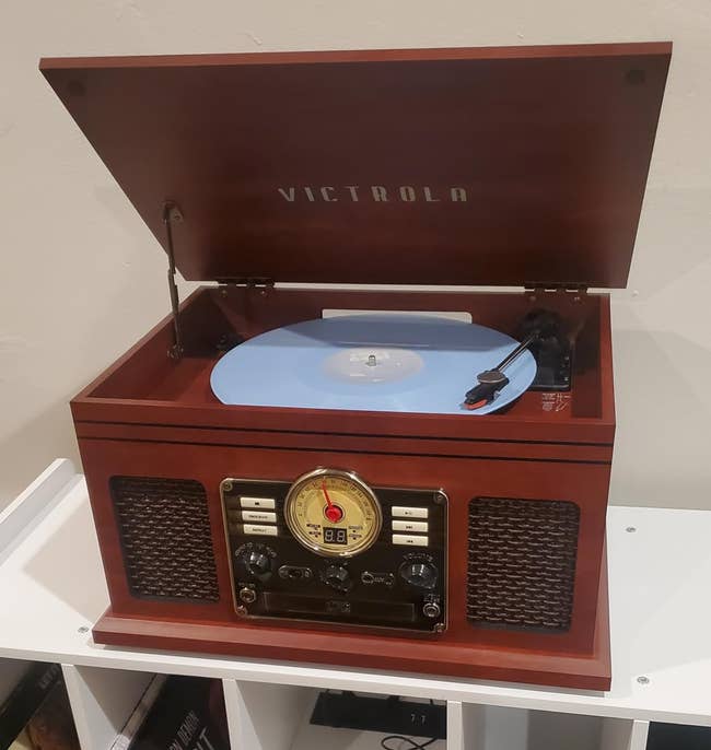 Open retro-style grounds subordinate with a vinyl connected a shelf, surrounded by books and CDs. Suitable for adding a vintage flair to location decor