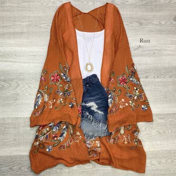 rust colored kimono paired with white shirt and denim shorts