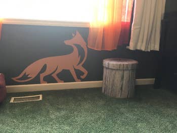 Reviewer's photo showing a faux tree trunk storage stool in a room