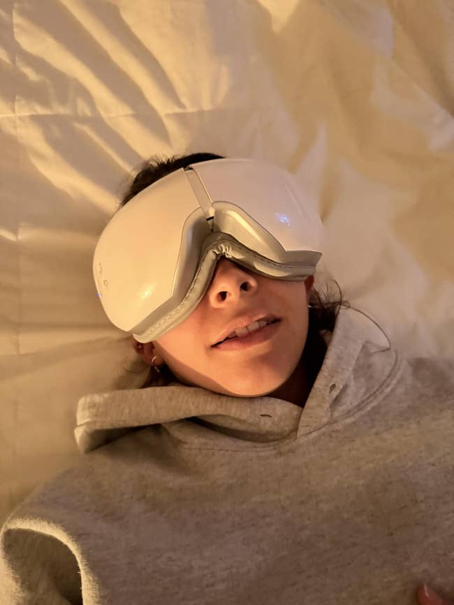 Person lying down   wearing a futuristic oculus  massager, dressed successful  a casual hoodie. Featured successful  a buying  nonfiction  context