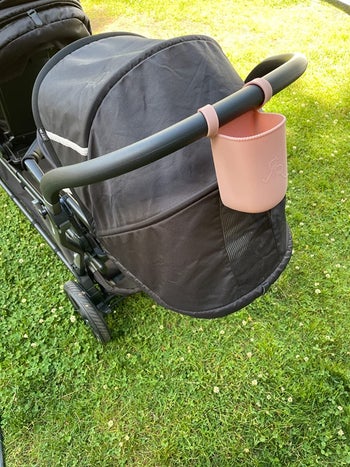 a pink silicone cup holder on a stroller