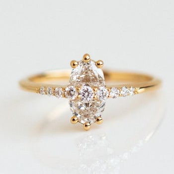 the ring with a gold band, two half moon diamonds to create an oval, and smaller diamonds across the middle