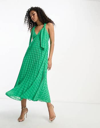 front view of a model in the pleated emerald green dress