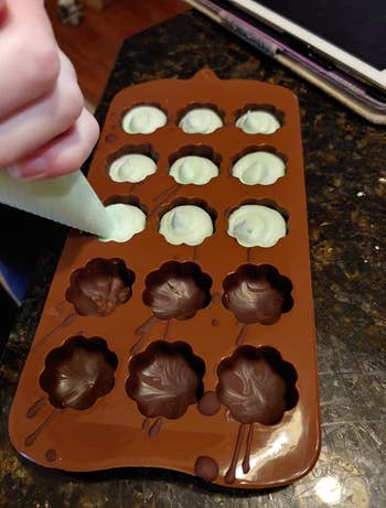 reviewer piping chocolate into a mold