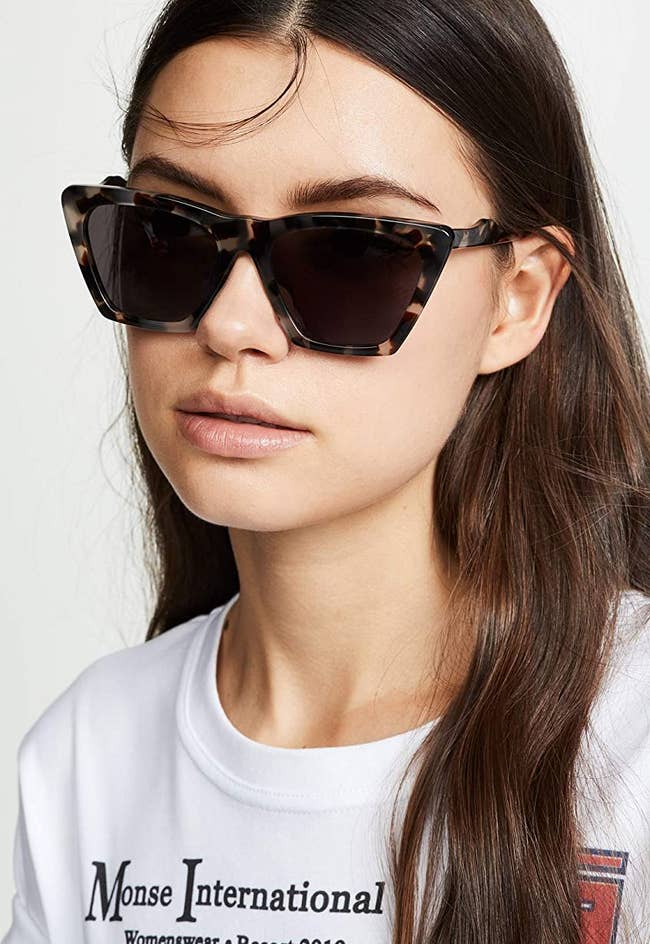 model wearing the modern cat-eye-shaped sunglasses in a tortoiseshell material