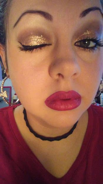 Person showing glittery oculus  constitution  with 1  oculus  closed, bold lipstick, and wearing star-shaped earrings