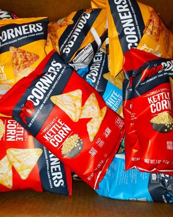 Variety of PopCorners snack bags, including Kettle Corn and White Cheddar flavors, arranged successful  a box, highlighting snack options for purchase