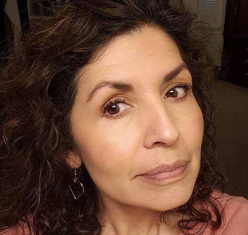 older reviewer with olive skin wearing a peachy blush