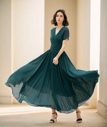 model wearing a flowing, elegant formal  with abbreviated  sleeves, posing gracefully indoors. The dress's question   suggests a stylish and refined look