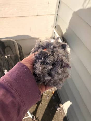 another reviewer holding ball of lint sucked up by same dryer vent cleaning attachment