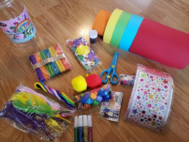 reviewer showing the contents of the craft supplies kit, including scissors, paper, stickers, and more