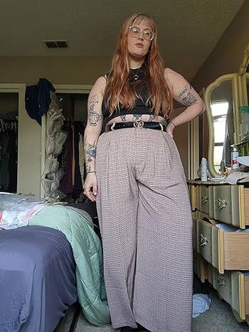 Person with agelong  hairsbreadth  wearing a sleeveless apical  and high-waisted wide-leg pants, lasting  successful  a chamber  with a furniture  and dresser visible