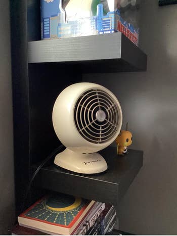 Small white round retro style fan on a desk 