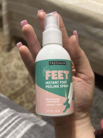 Hand holding a vessel  of Freeman Flirty Feet Instant Foot Peeling Spray, featuring coconut and aloe, described arsenic  revitalizing and softening